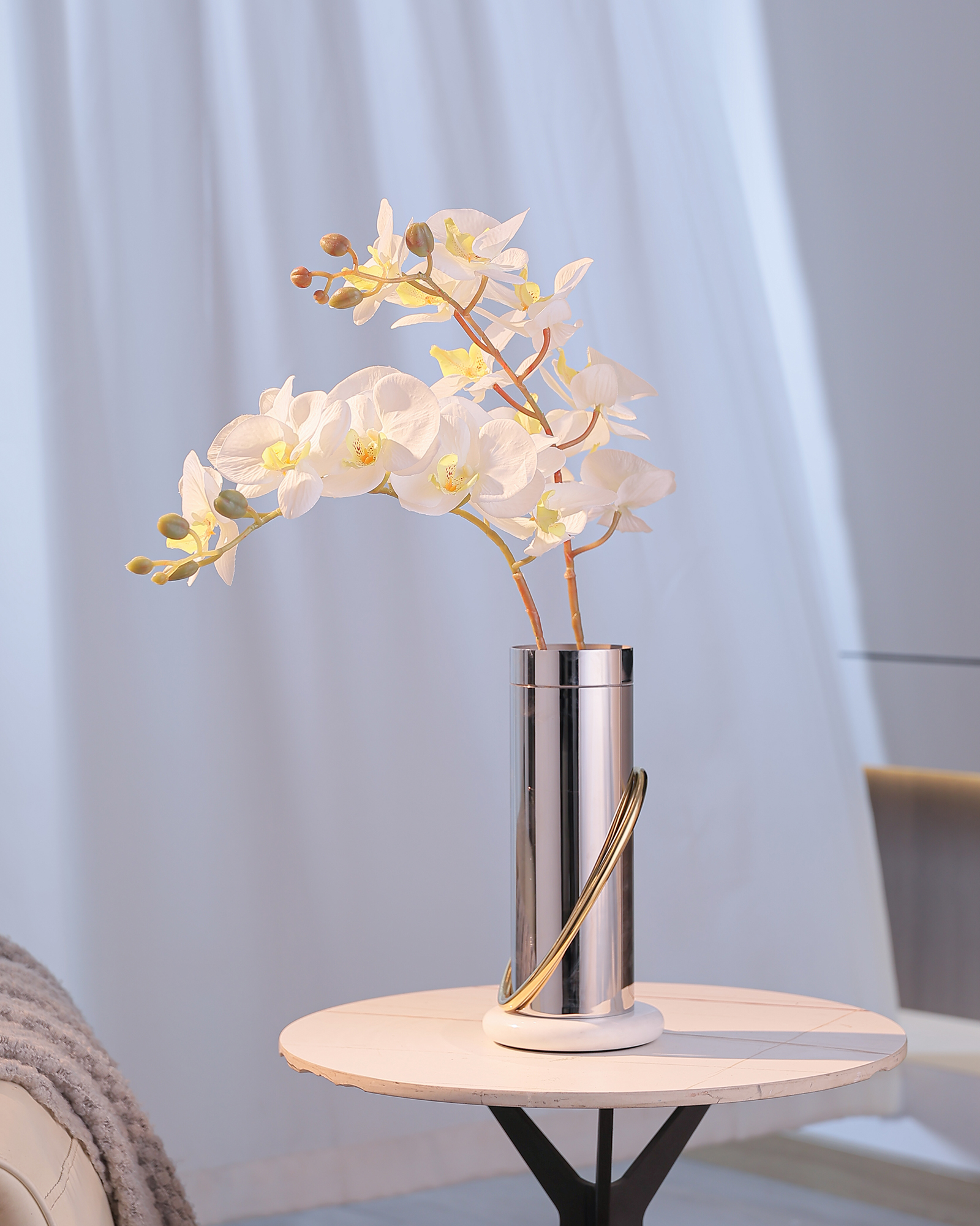 Decorative metal vase with flowers in a softly lit room